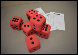 six red foam dice and Yahtzee score sheets