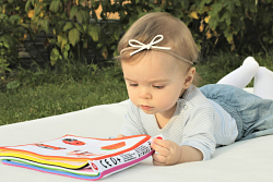 Baby on a blanket with a book
